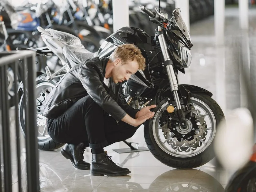 Motard qui examine une moto dans un showroom